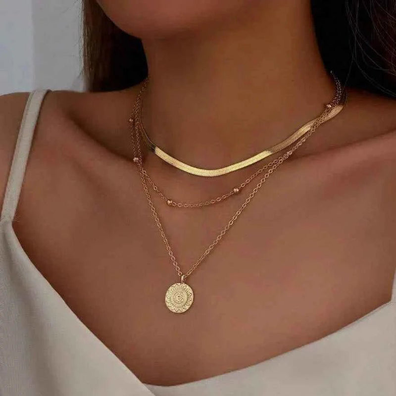 Liora – Triple-layer necklace in gold finish with sunflower medallion