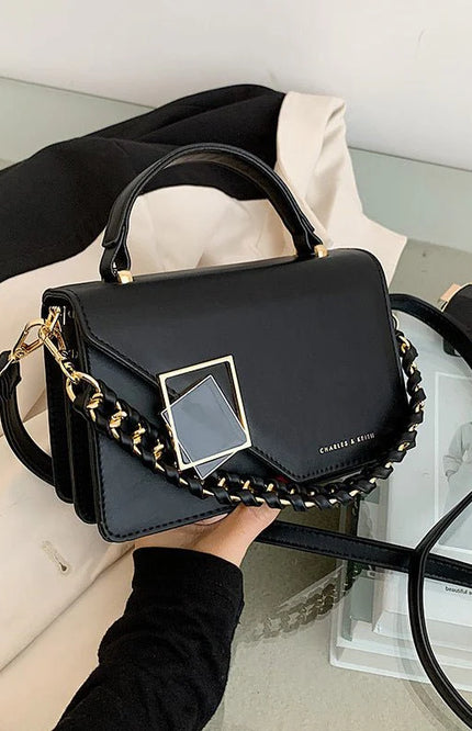Emma – Sac bandoulière structuré avec détail chaîne et fermeture géométrique